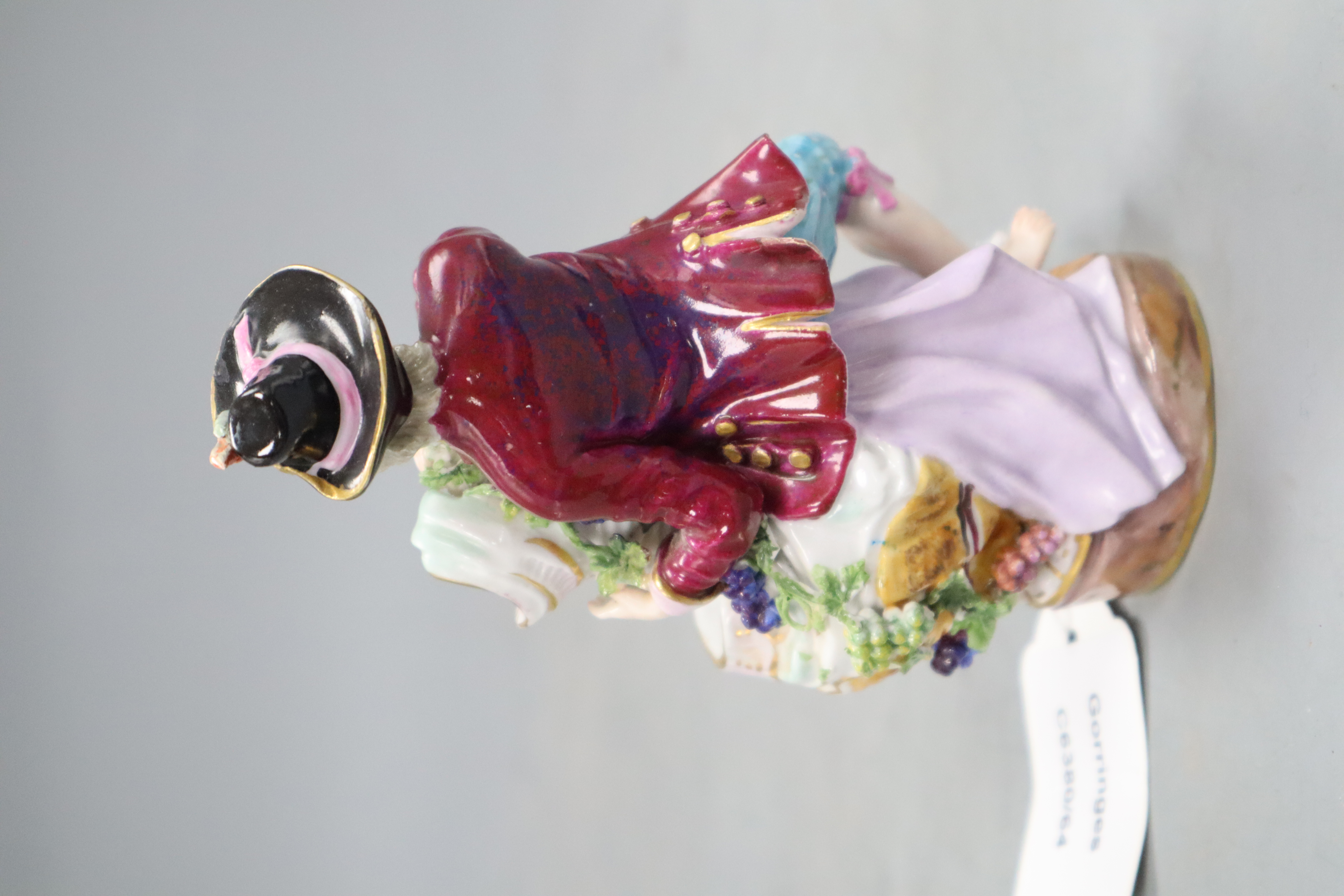 A late Meissen figural salt, modelled as a seated gallant and companion beside a floral encrusted shell